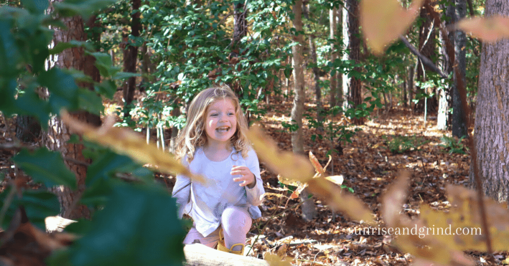 little girl smiling in the woods